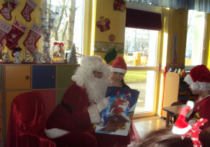 Mikołaj wręcza prezent Karinie